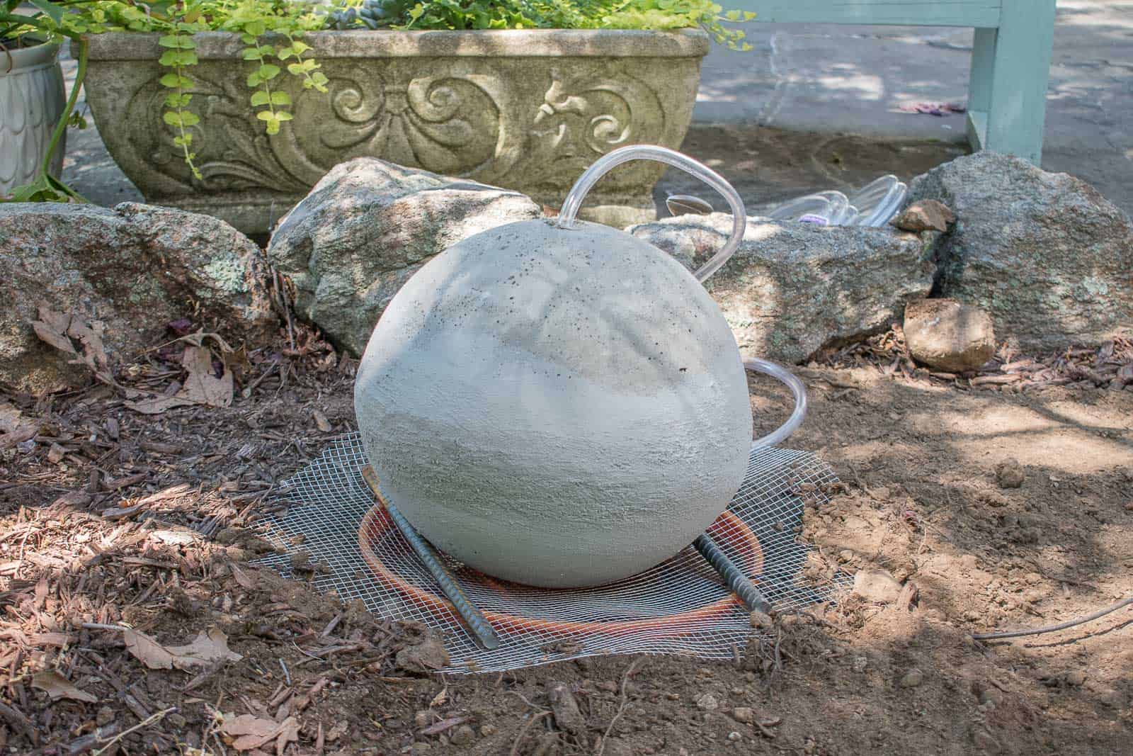place hardware mesh over the bucket and support fountain with rebar