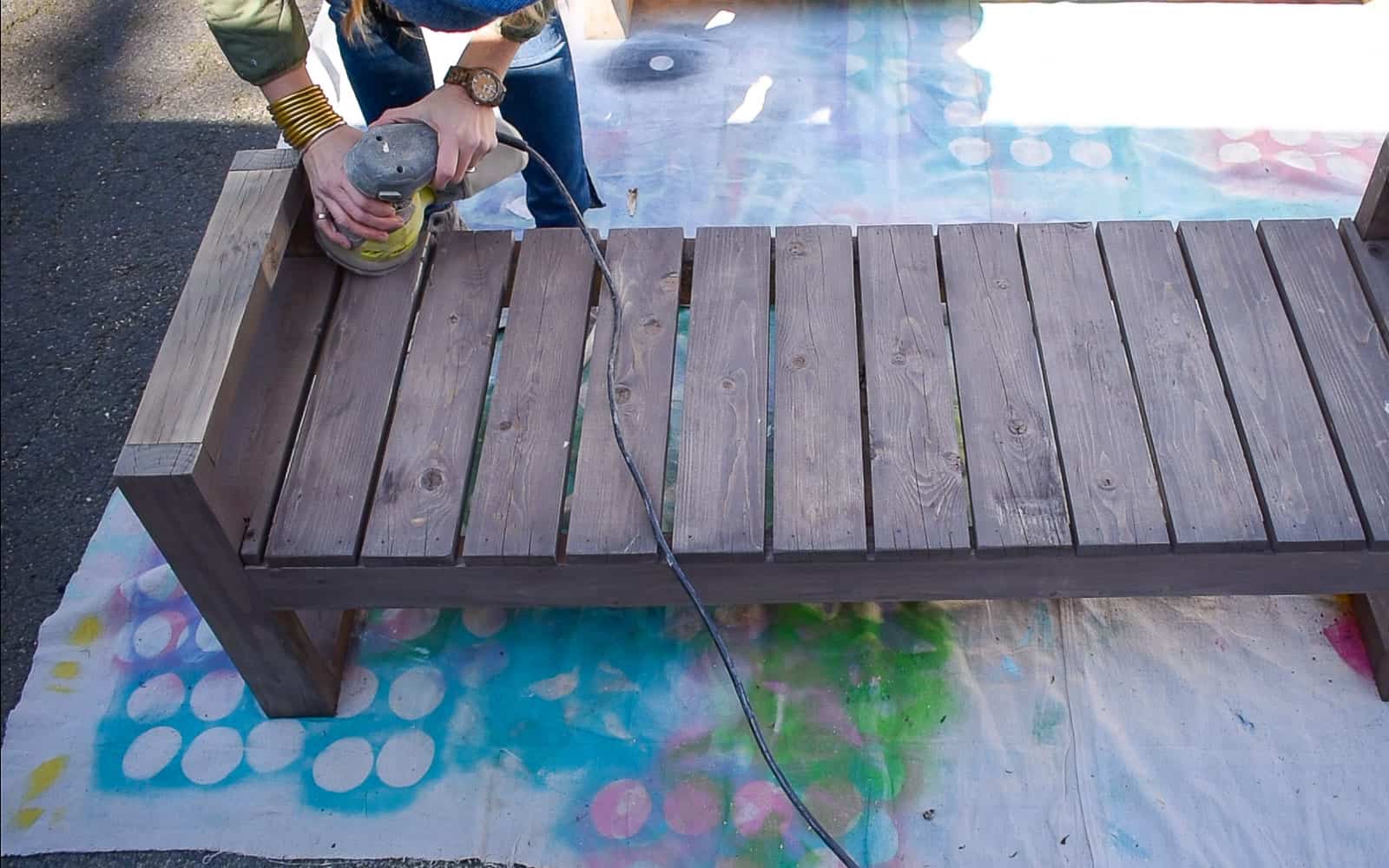 lightly sand benches to prep for paint