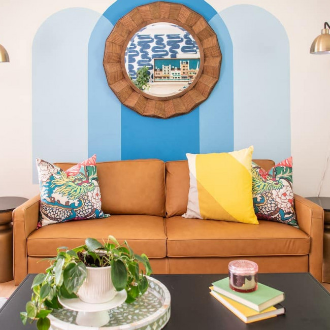 Colorful family room with brown leather couch and blue walls.