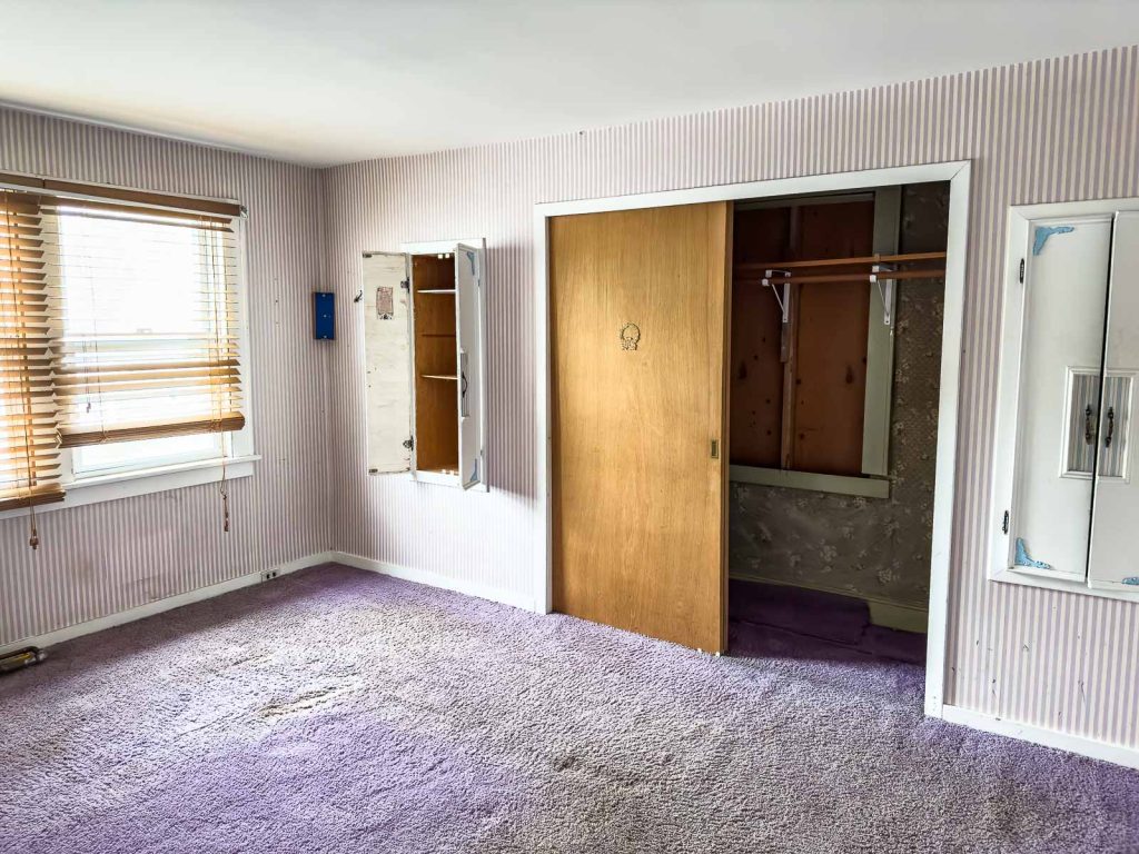 upstairs primary bedroom with purple carpet