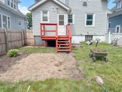 clearing the grass from the patio at the flip house