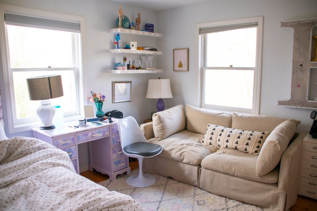 girls bedroom with tan loveseat, floating shelves and painted wooden desk