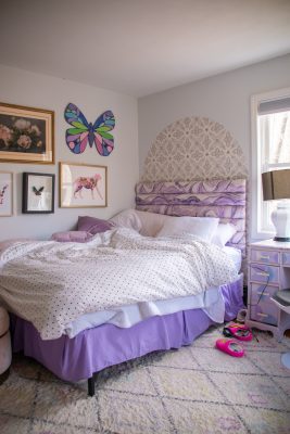 girls lavender bed with gallery wall hanging above